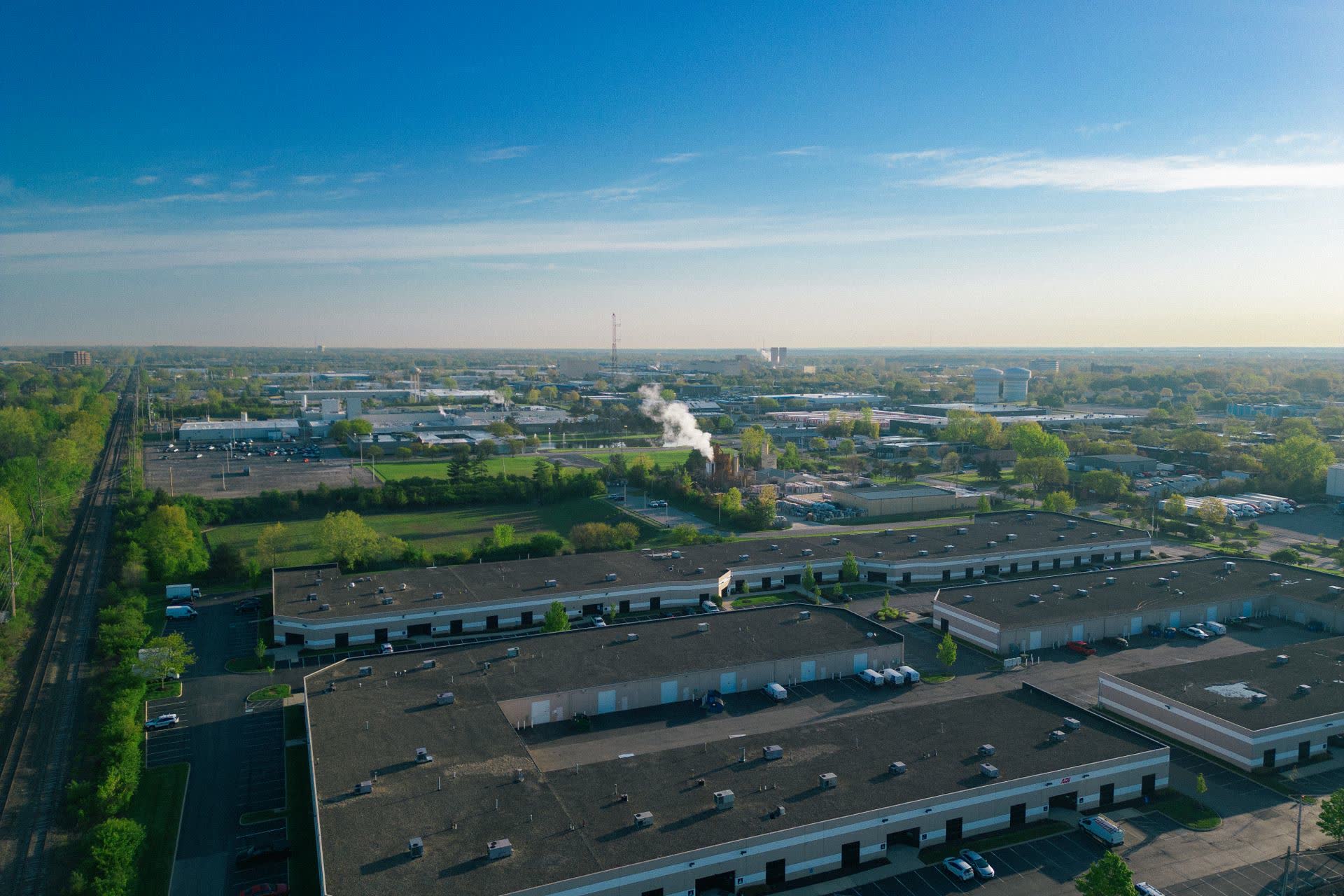 Aerial view of an industrial park and warehouses, Iron Ridge Advisors helps commercial property owners defer capital gains tax on a sale