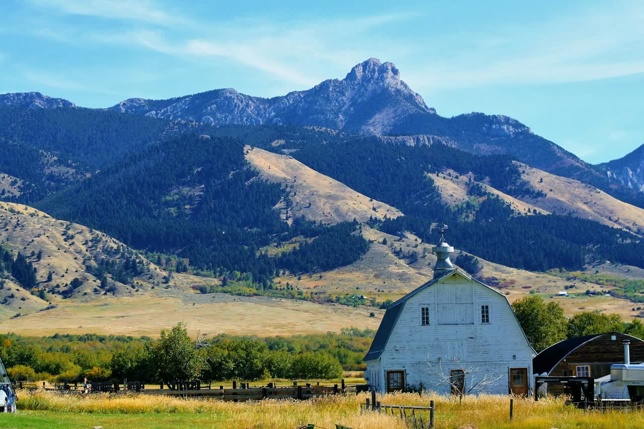 A white barn under Montana mountains, the kind of generational land Iron Ridge Advisors helps families protect through estate planning